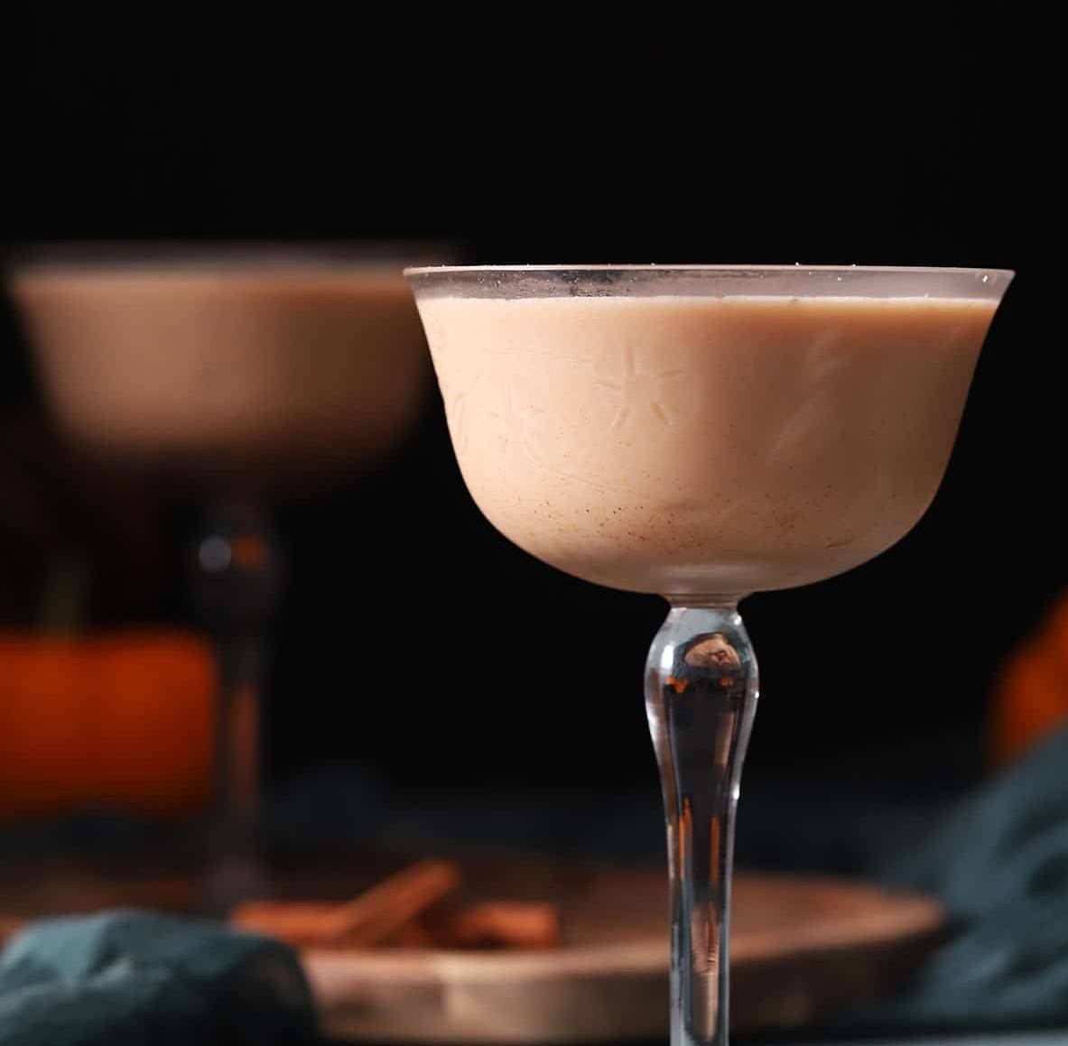 A stemmed glass holds a creamy pale brown drink.