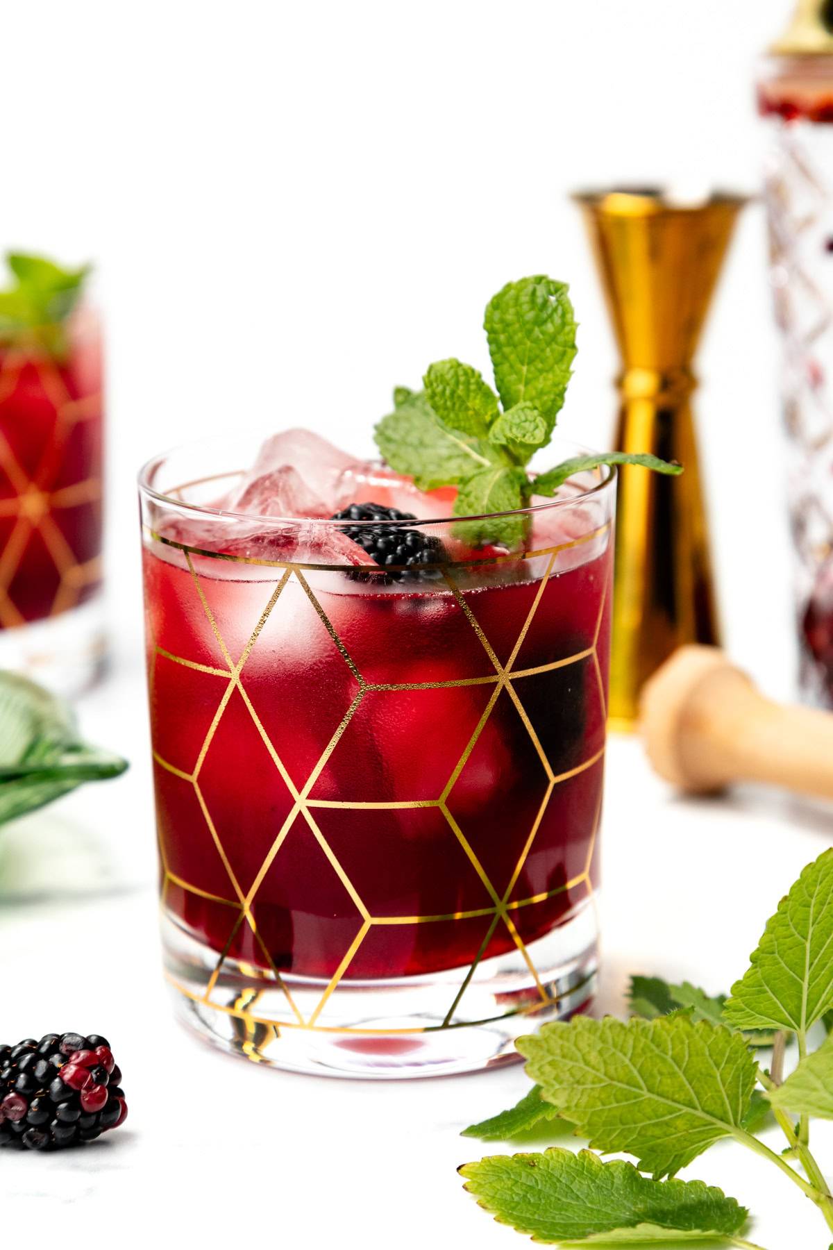 A deep red drink with blackberries and mint.