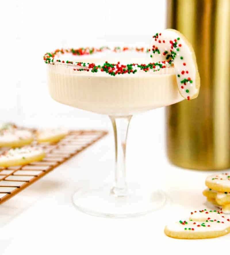 A creamy white martini is rimmed with red, white and green sprinkles.