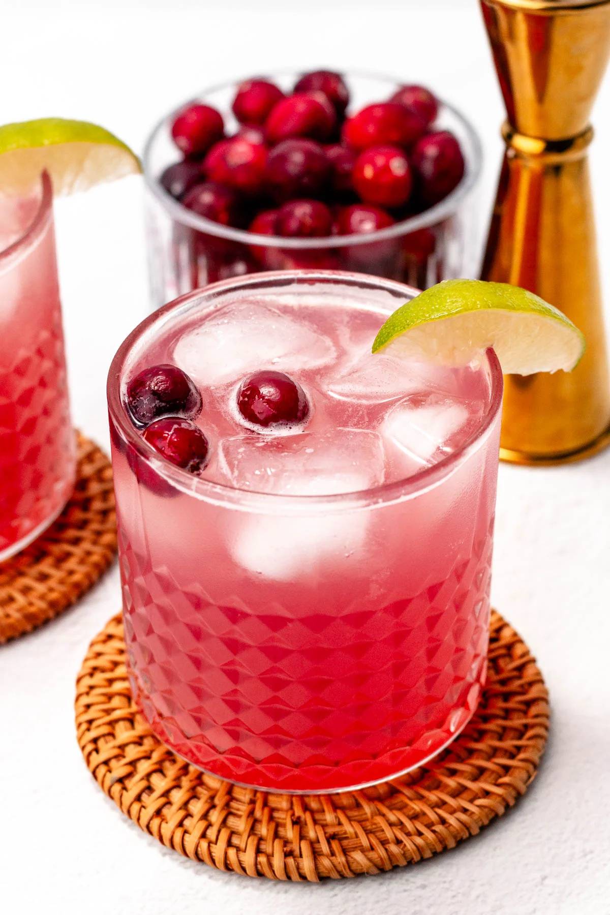 A red drink sits on a rattan coaster.