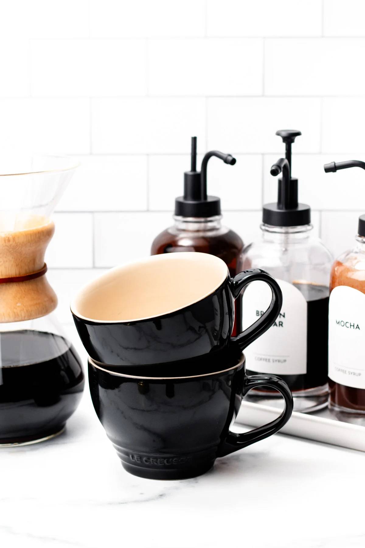 Coffee cups sit near simple syrups.