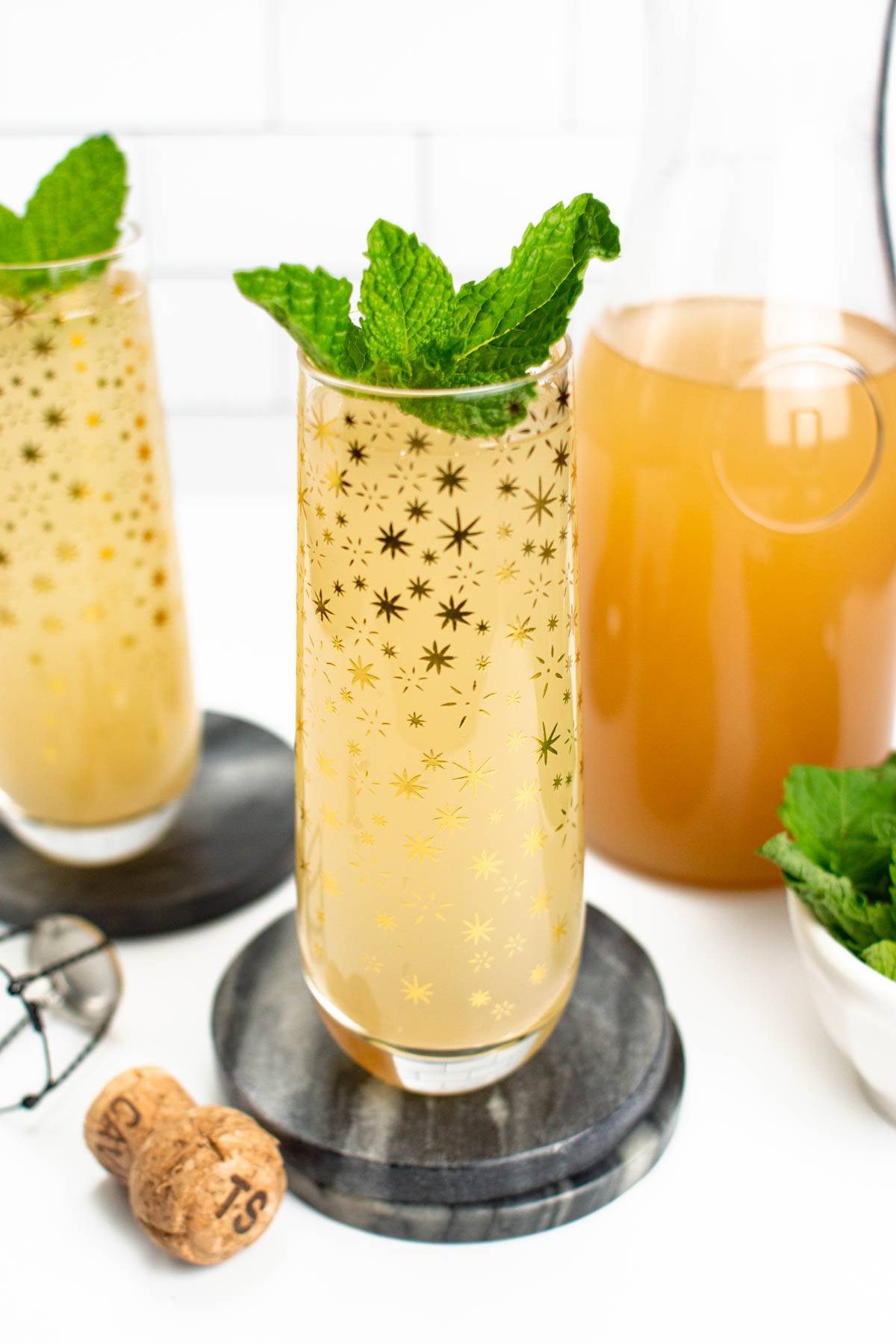 Guava mimosas in stemless flutes decorated with gold stars.