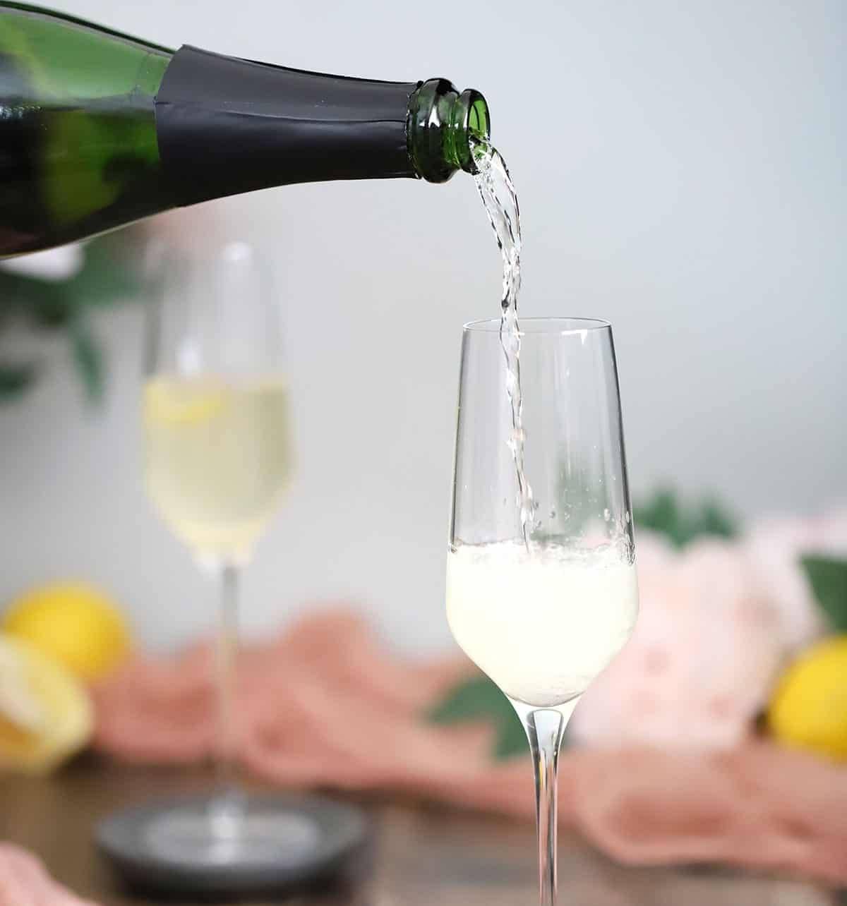 A sparkling wine is poured into a champagne glass.