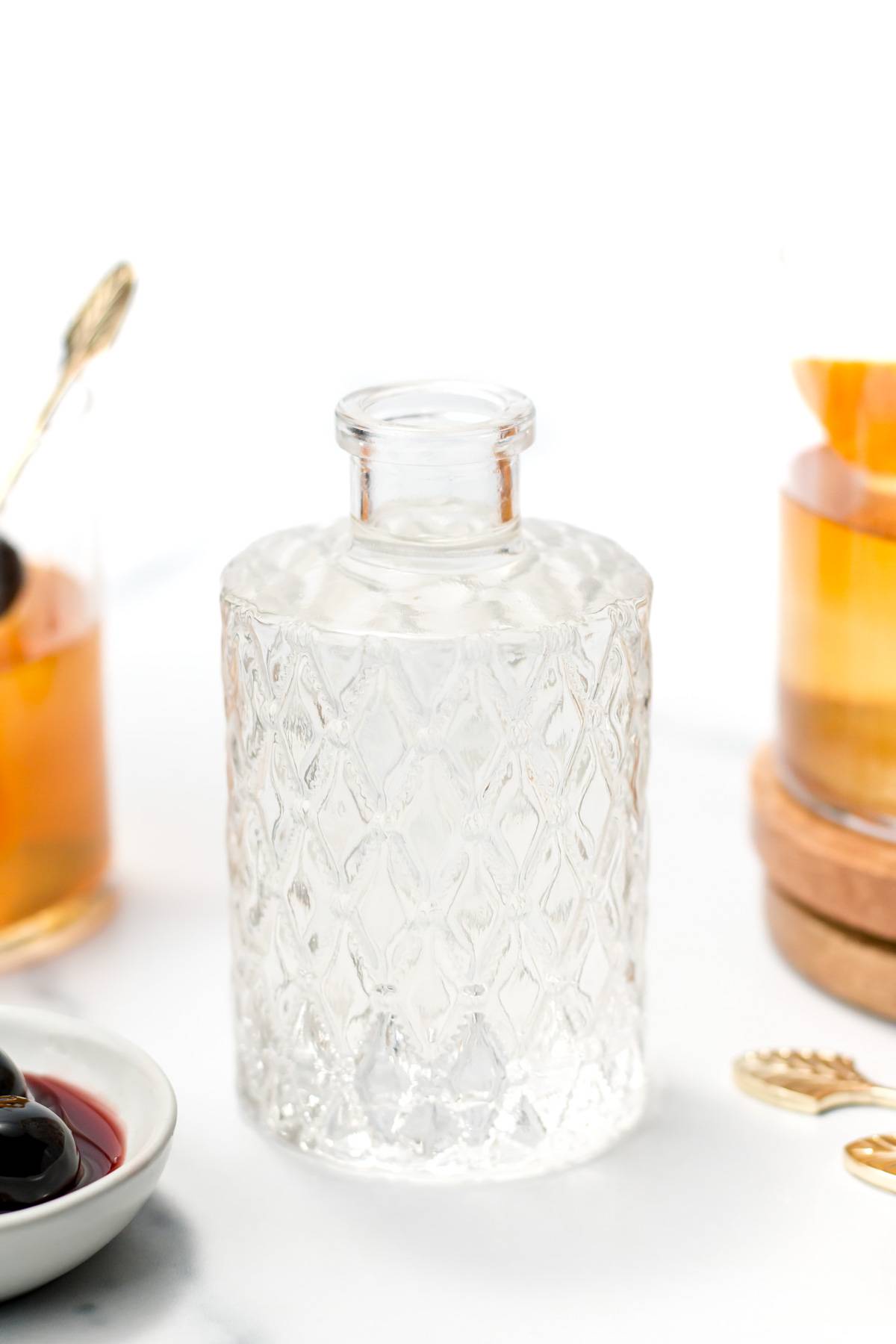 A decorative glass bottle of clear simple syrup.