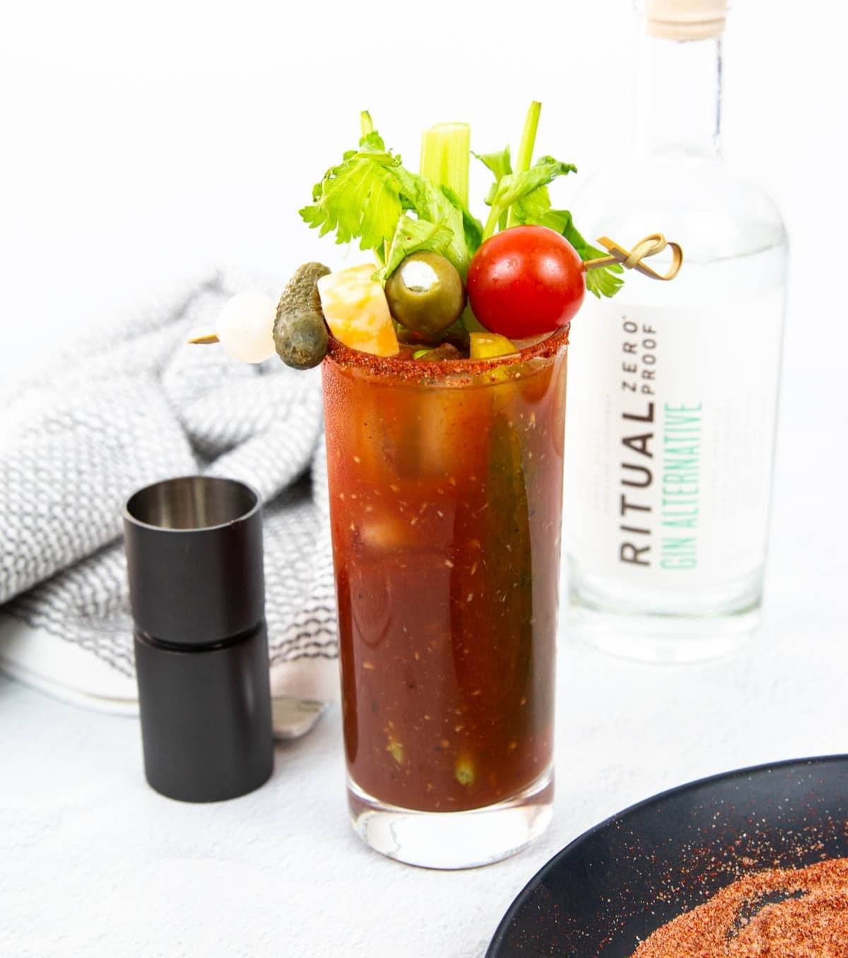 A bloody mary sits by a bottle of nonalcoholic vodka.