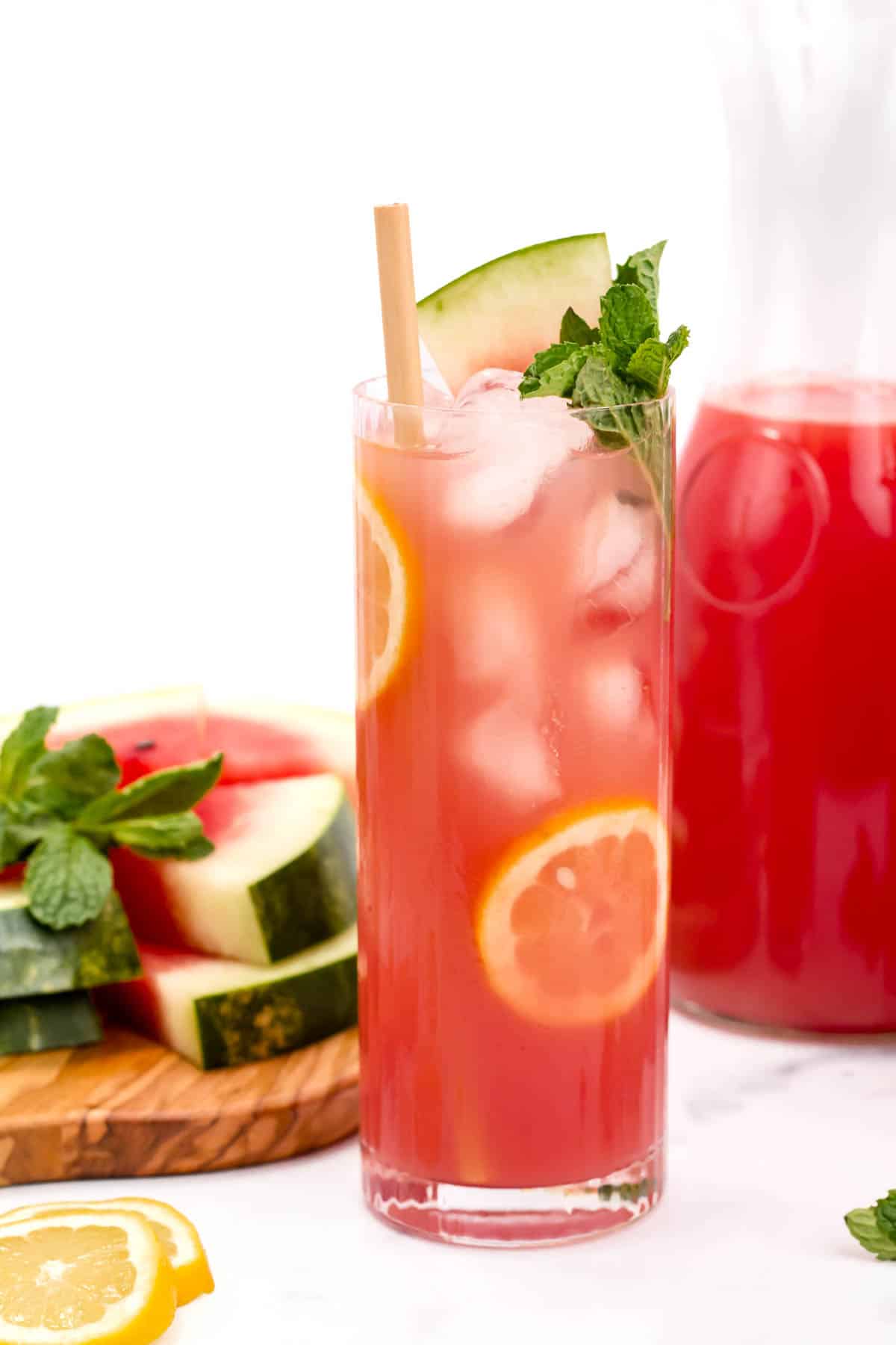A deep pink drink with lemon rounds and a mint sprig.