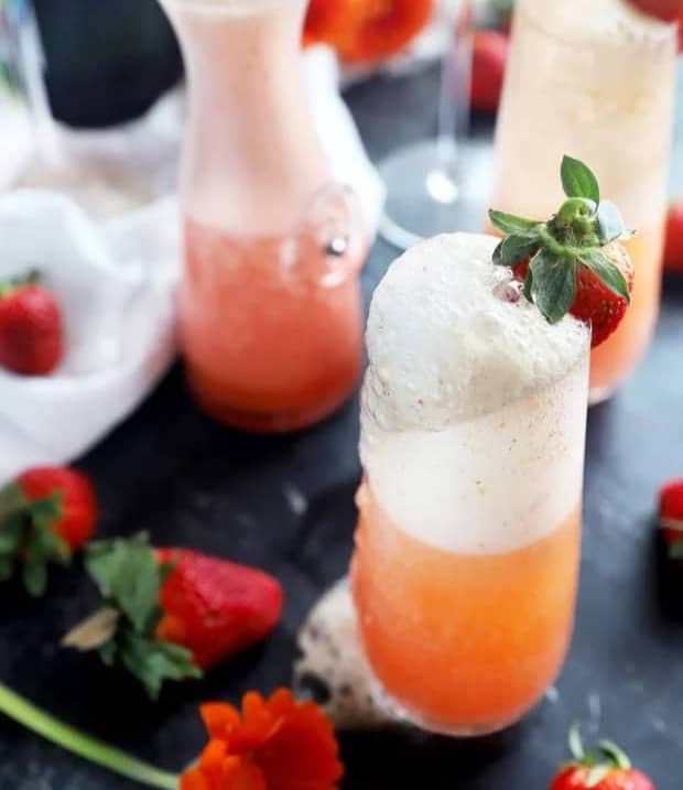 A bubbly strawberry cocktail in a stemless champagne flute.