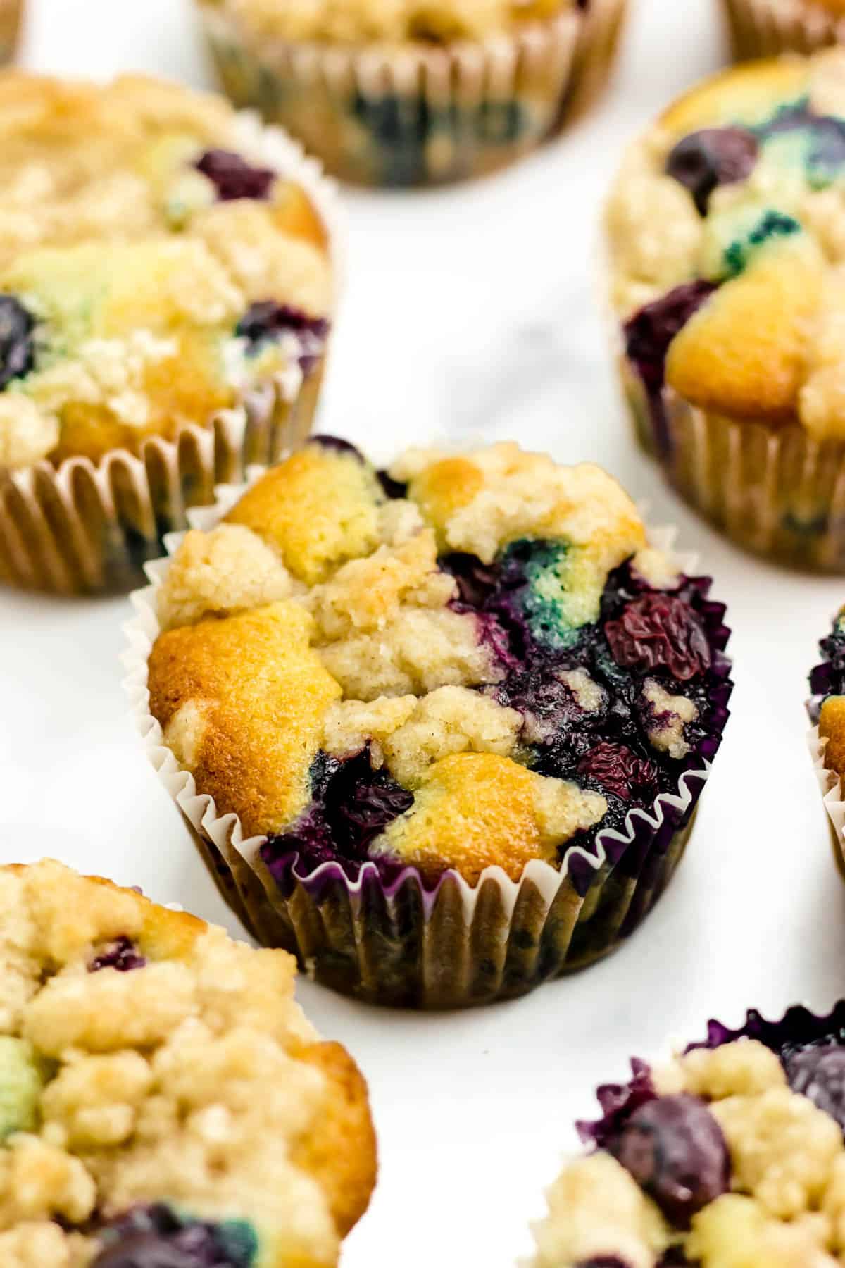 Blueberry muffins on a white marble surface.