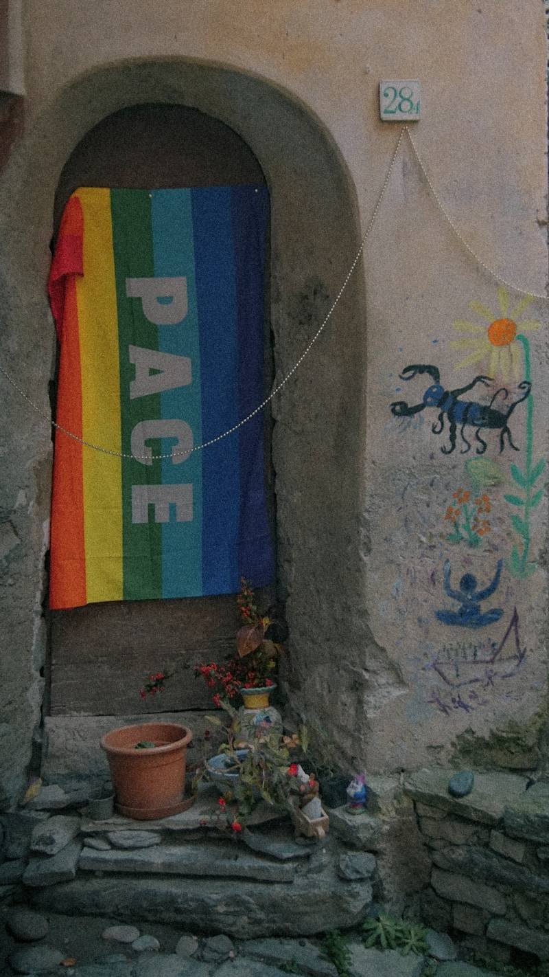 A rainbow flag hanging from the side of a building