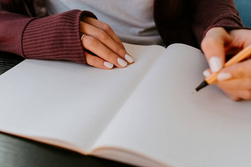 person writing on white paper