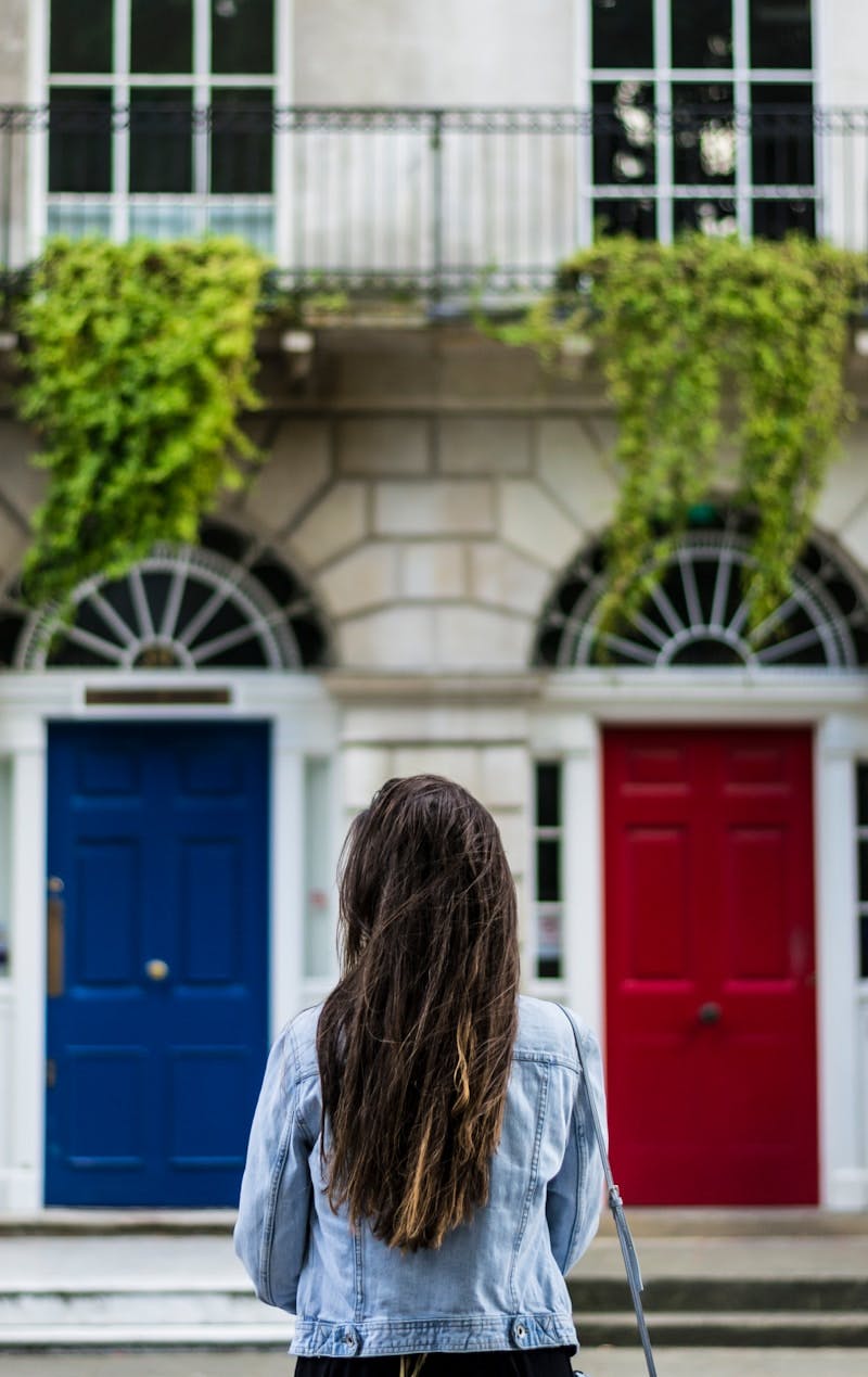 woman with jacket on front of concrete building