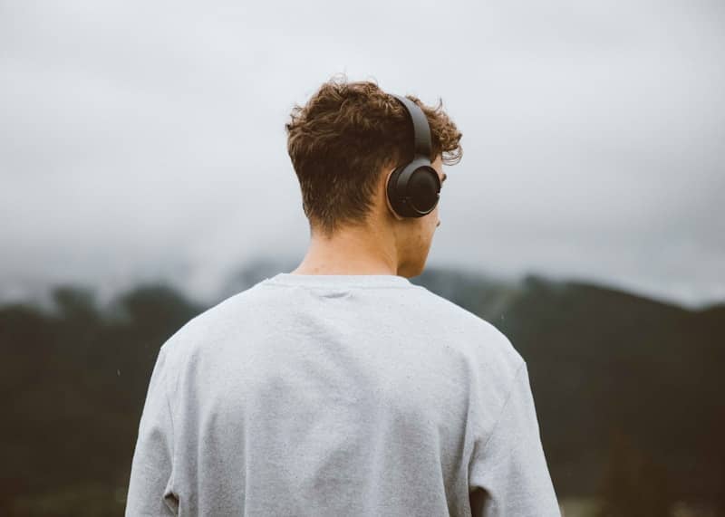 a man with headphones on looking at the mountains