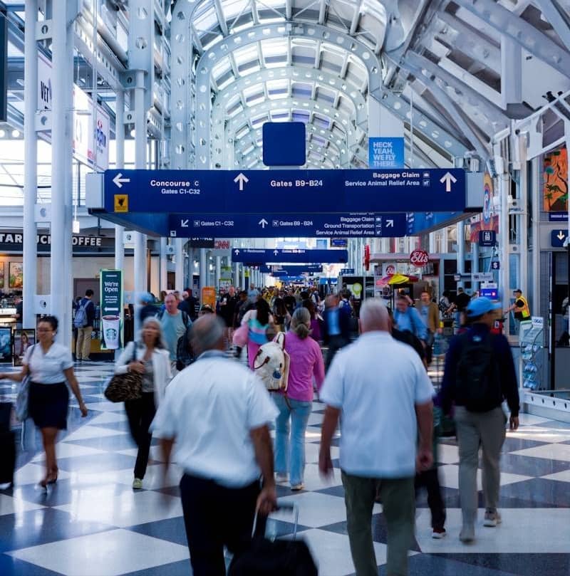 People walk through an airport terminal.
