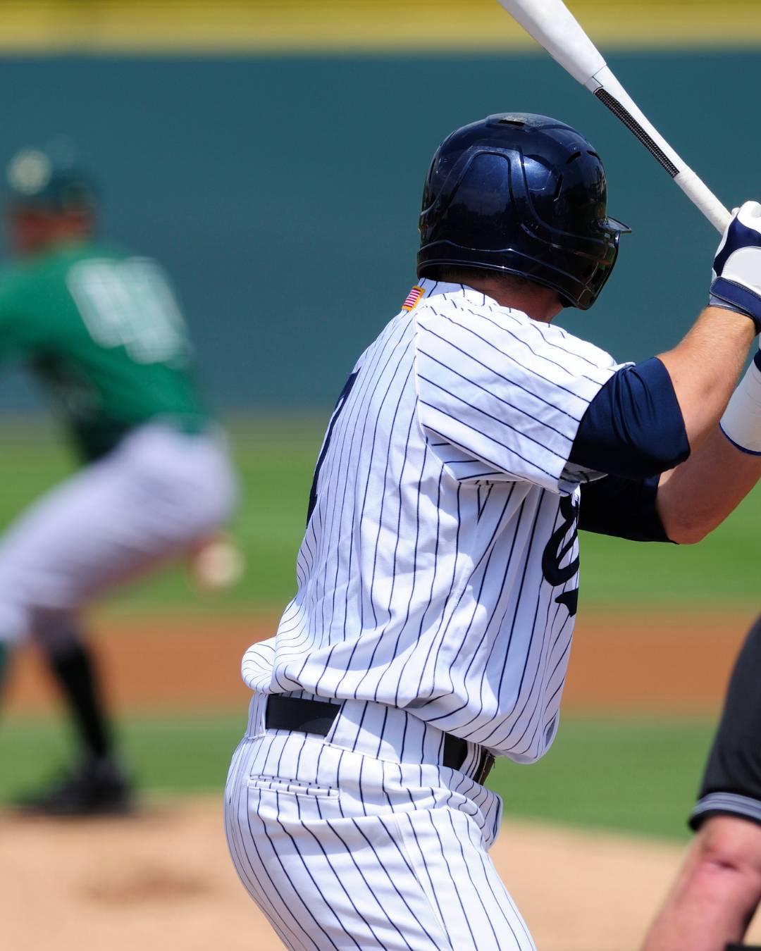 A baseball player holds his bat ready for the next pitch. 