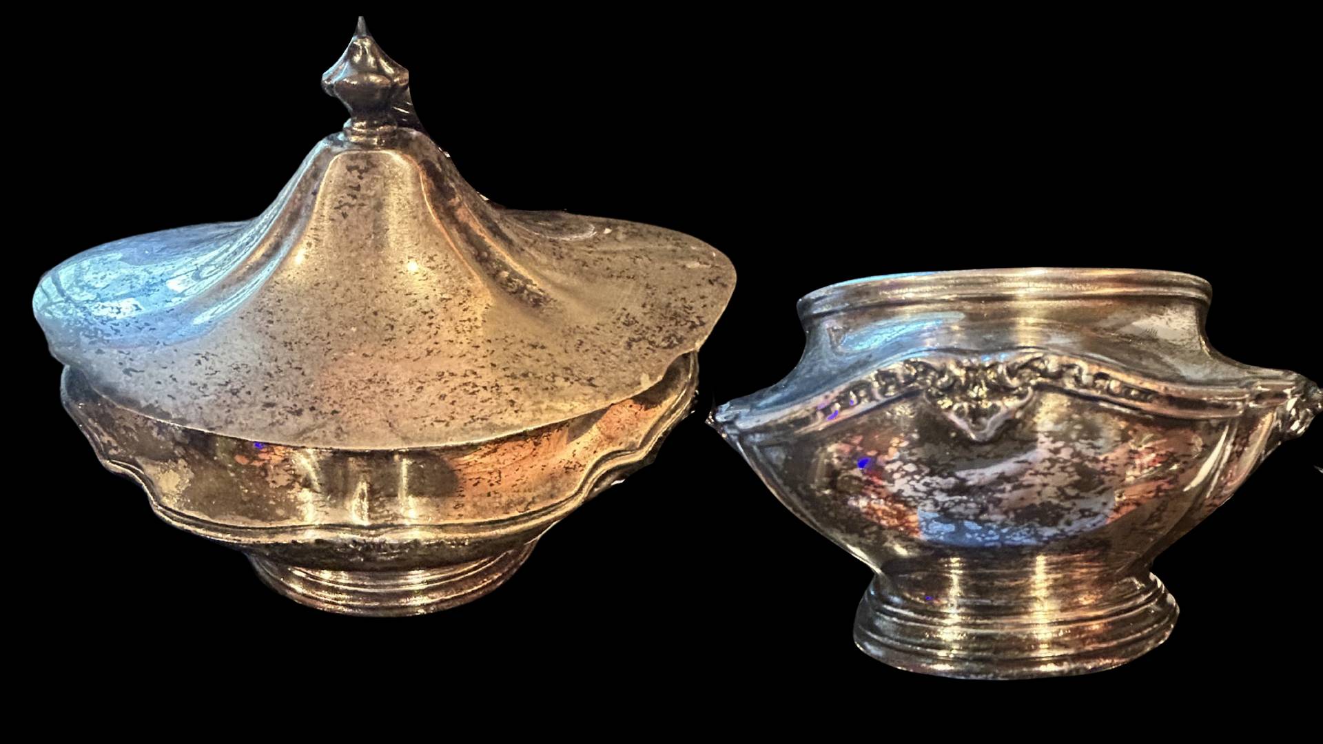 An old silver plated hotel serving dish and lid covered in black tarnish.