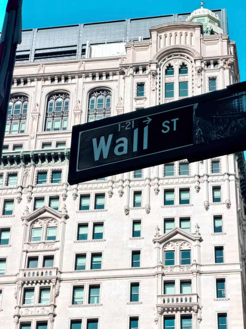Wall street sign in front of a historic building.