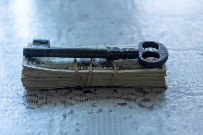 A key sitting on top of a pile of money