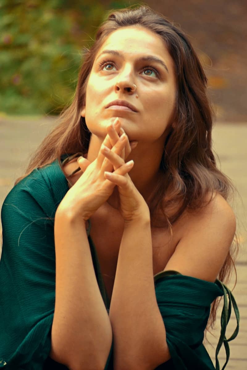 A woman looks upward, deep in thought.