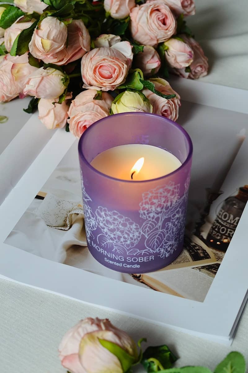 Lit candle, flowers, and a stylish magazine.