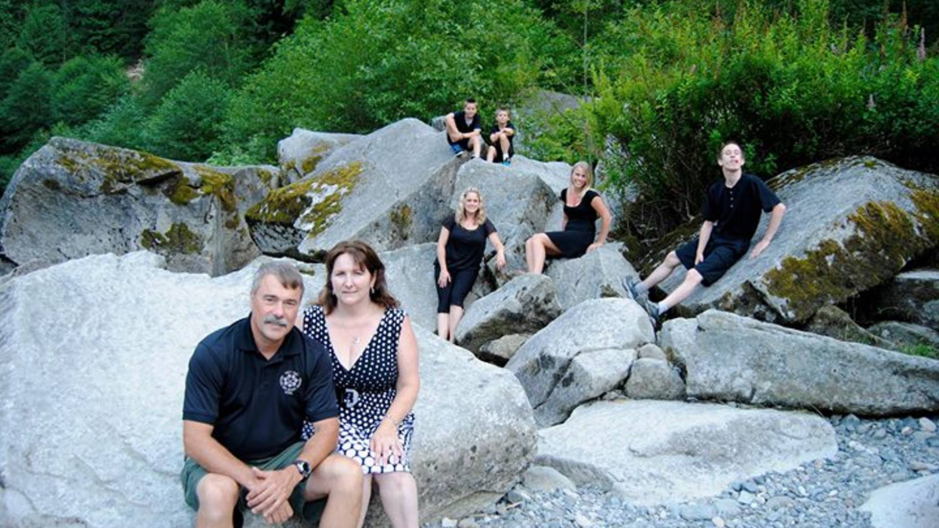 Family of seven sitting on rocks