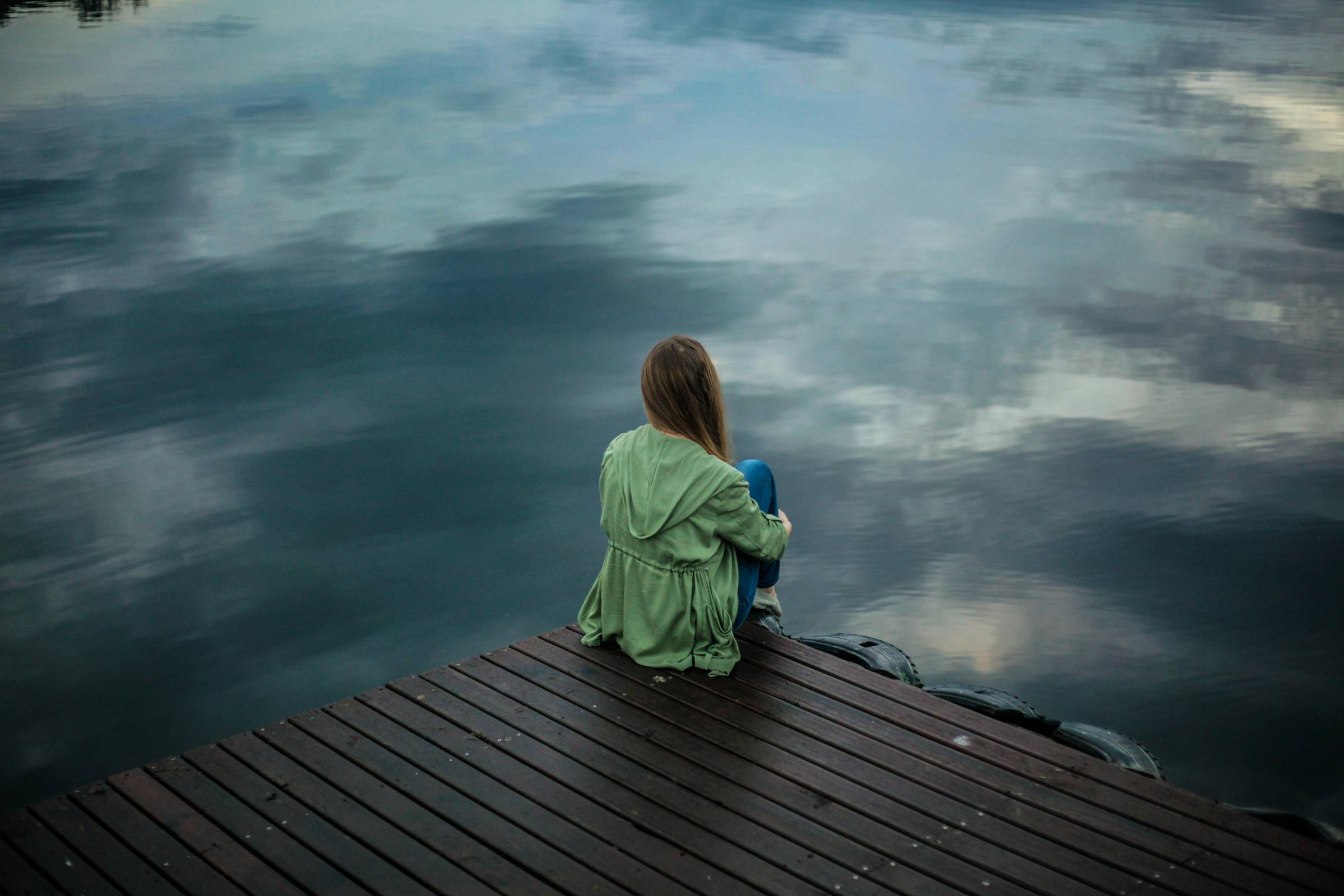 Woman sitting on a dock gazing out