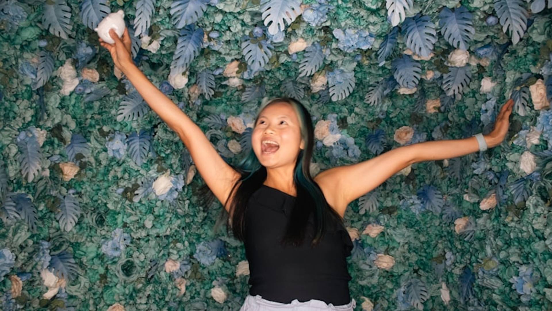 A woman standing in front of a green wall