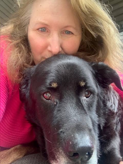 Woman resting her head atop of her dogs head