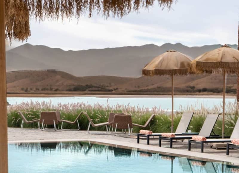 Resort pool with lounge chairs and distant mountains