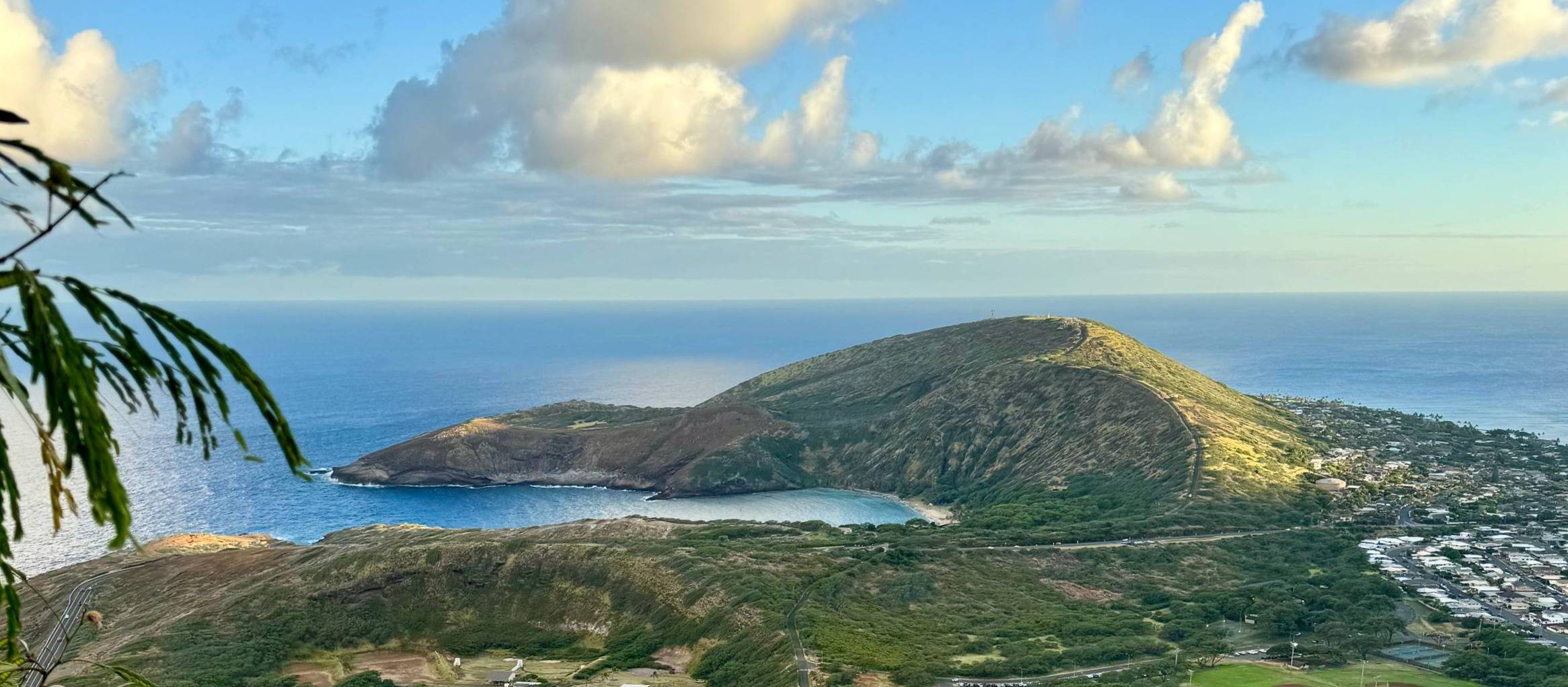 aerial view of Hanauma Bay, Hawaii - blue water with a beach and green mountain