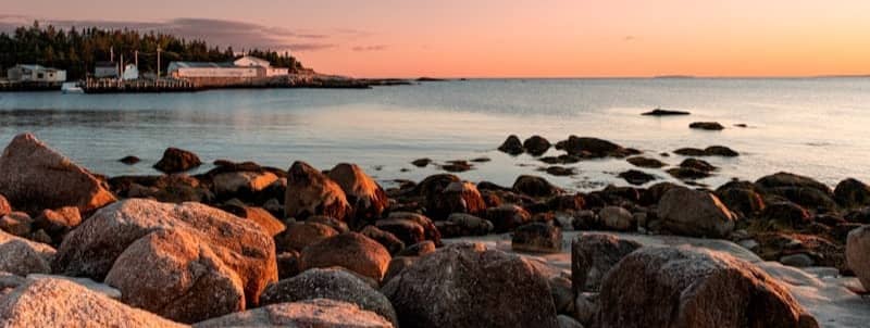 Rocky coastline at sunset with calm ocean waters