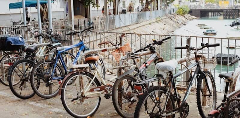Several bicycles parked along a waterfront railing.