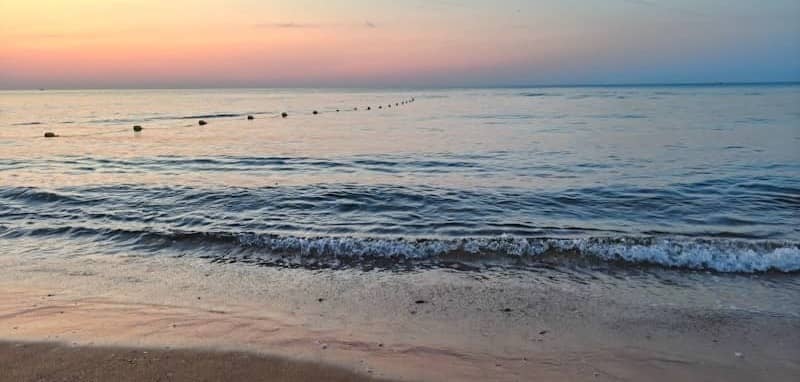 Sunset over the ocean, with a calm, serene view.