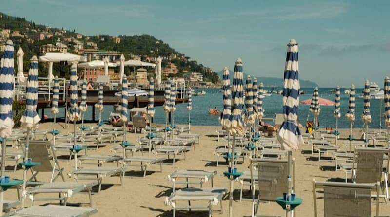 Empty beach with umbrellas and lounge chairs.