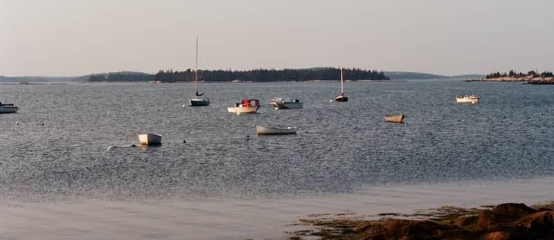 Several boats float on a calm blue bay.