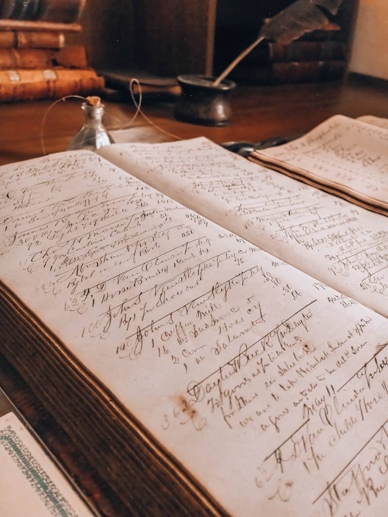 Old ledger book with handwritten entries and an inkwell.