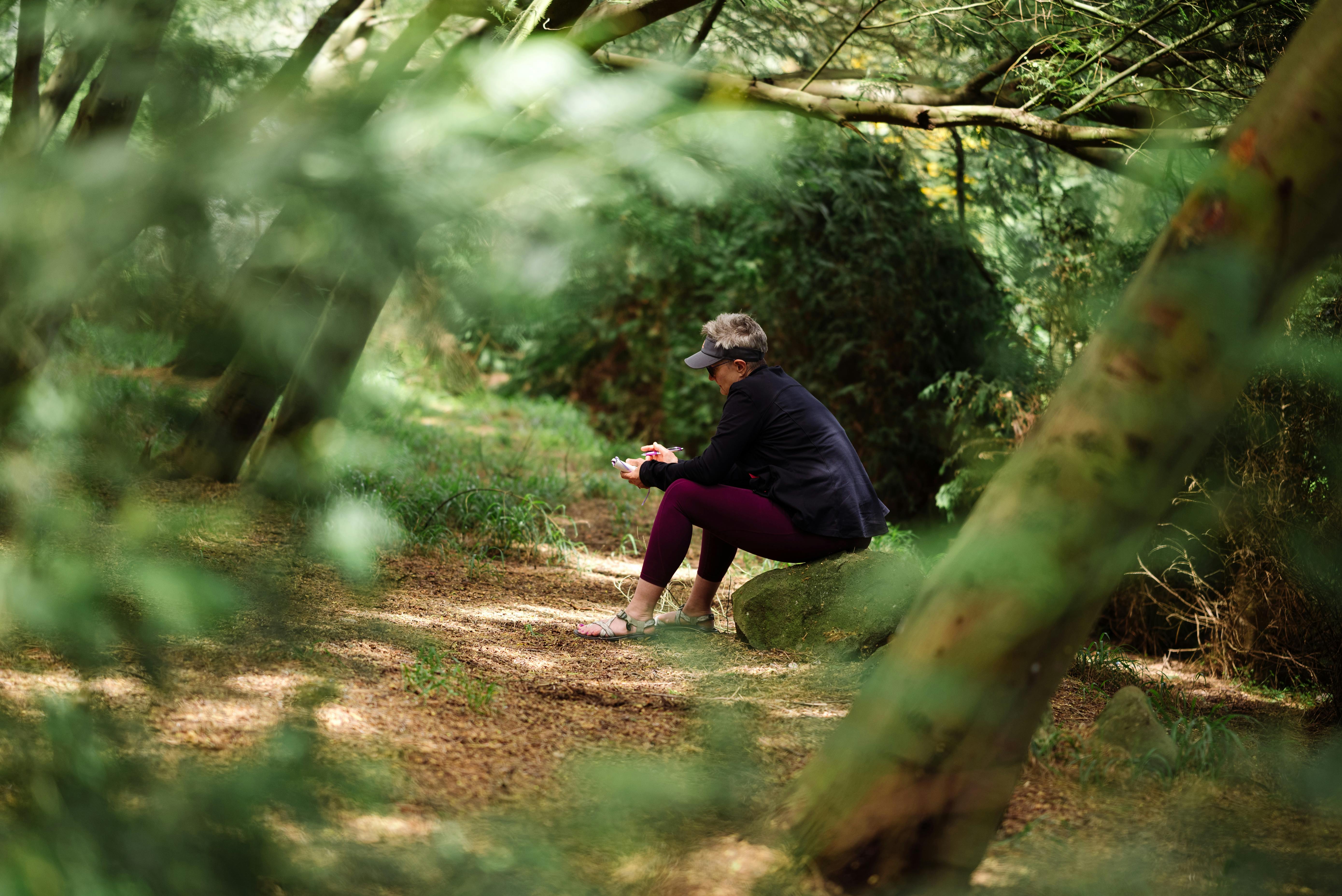 Woman sitting in nature with journal