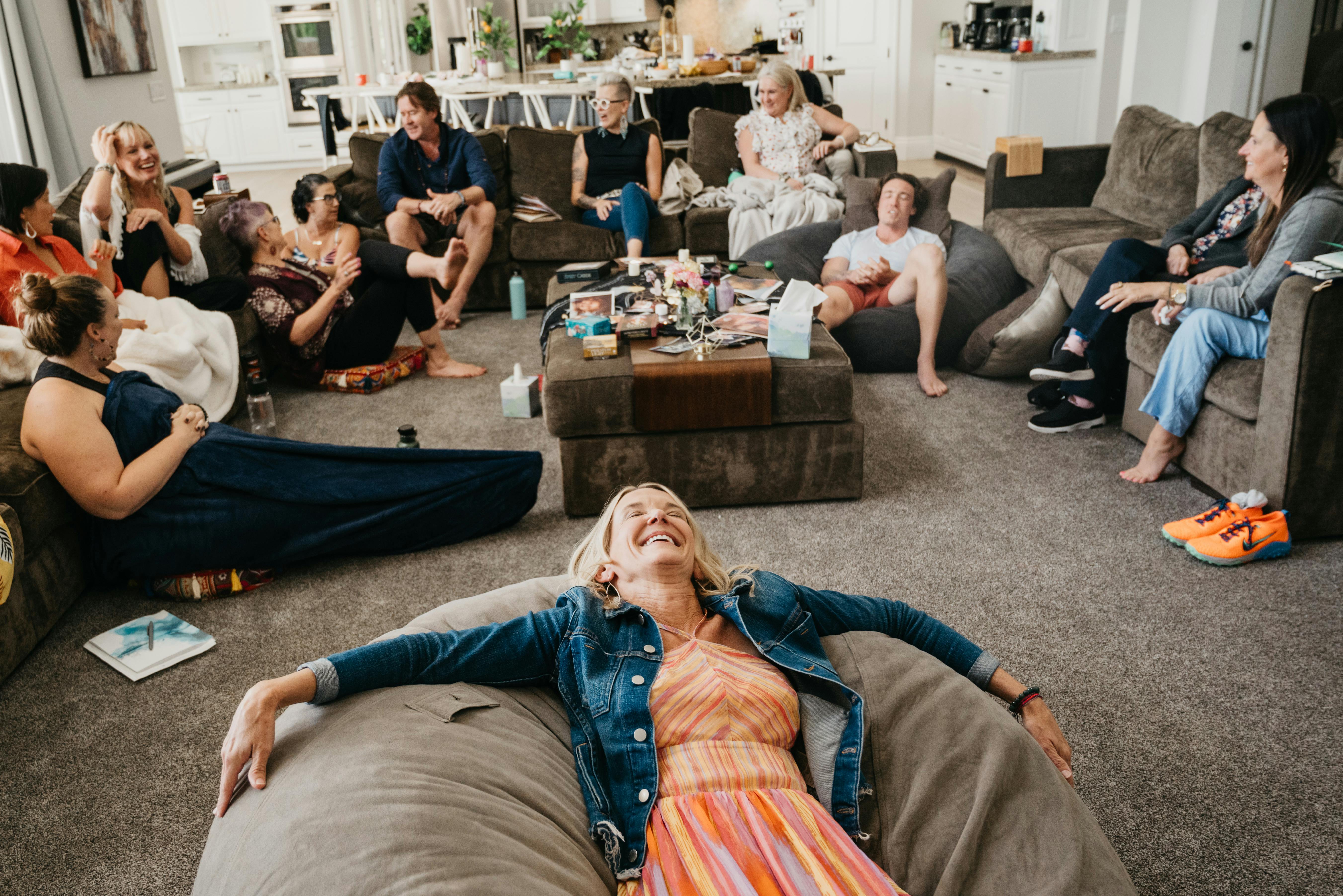 A woman laying on a beanbag with her back to a group of people