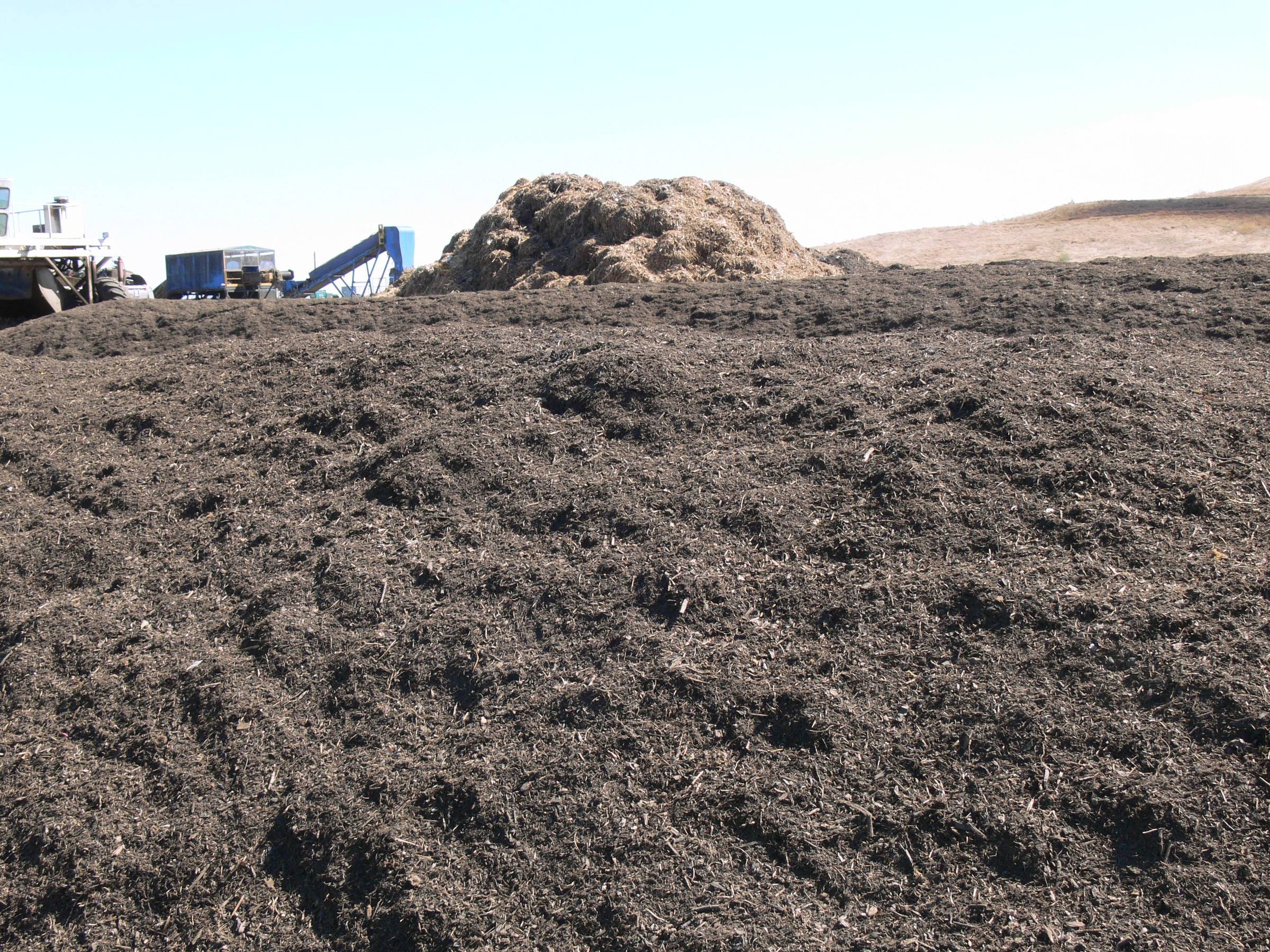 a mountain of finished compost at a composting facility