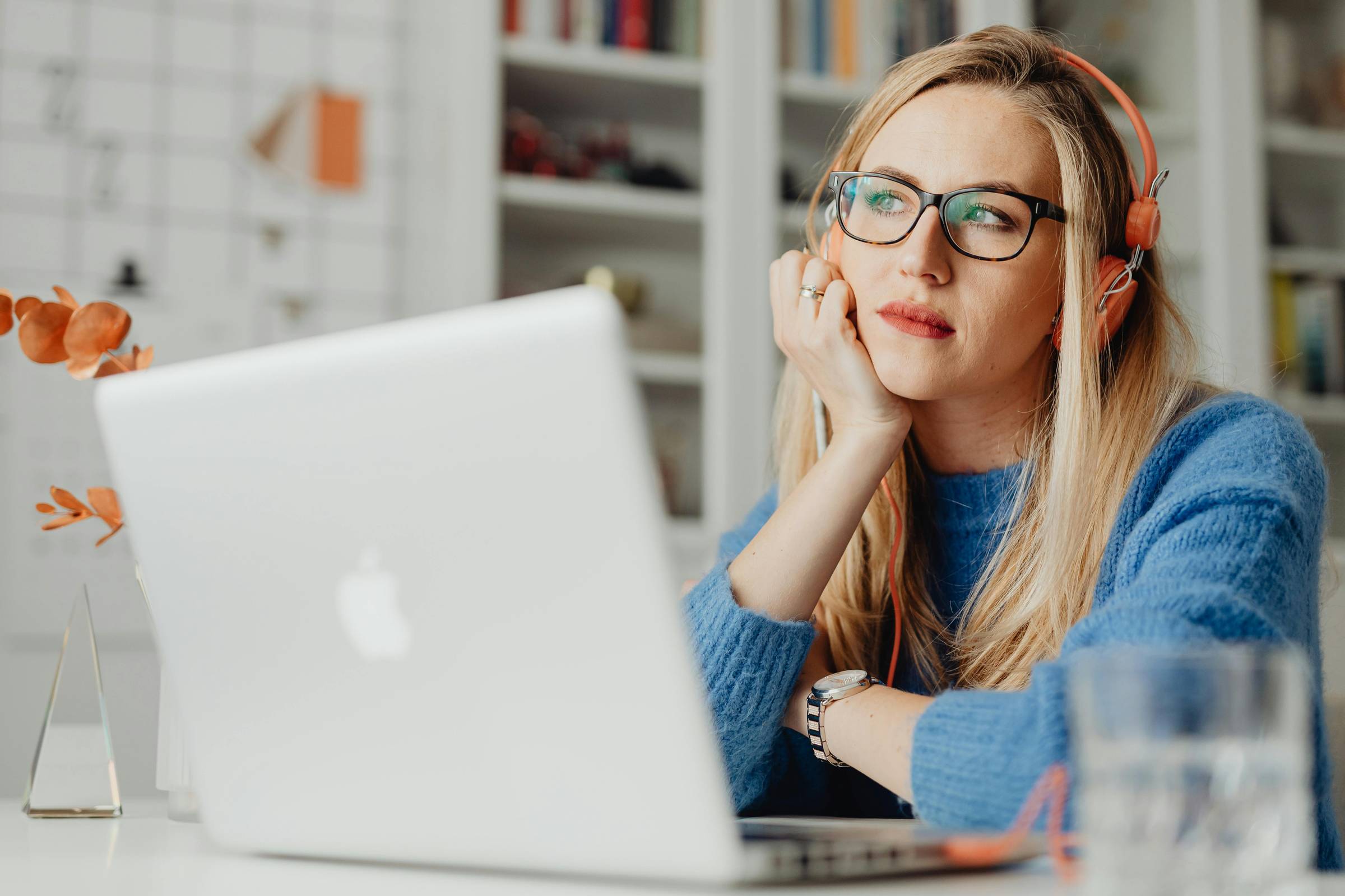Women wearing headphones, staring off into the distance. 