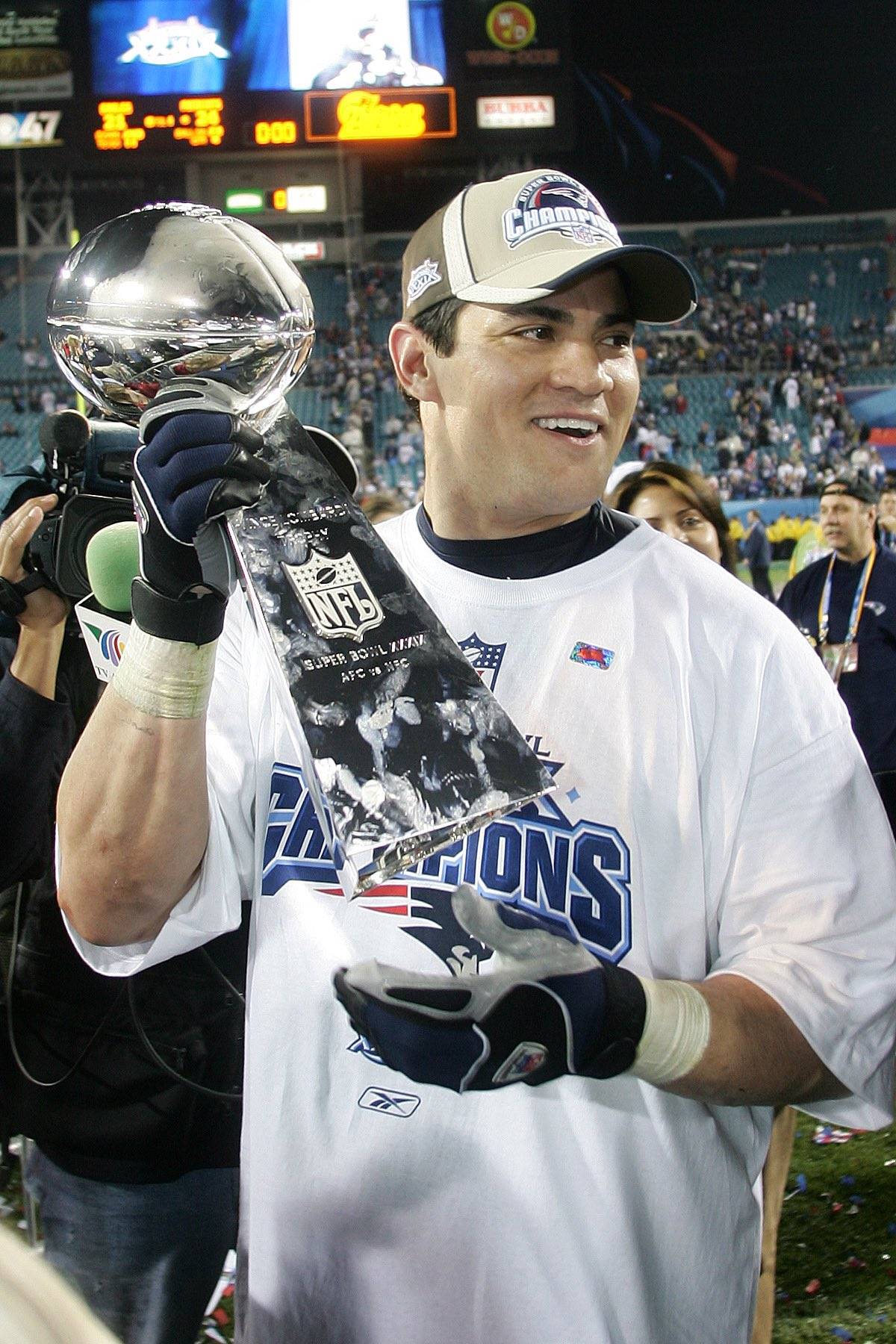 Tedy Bruschi holding a trophy