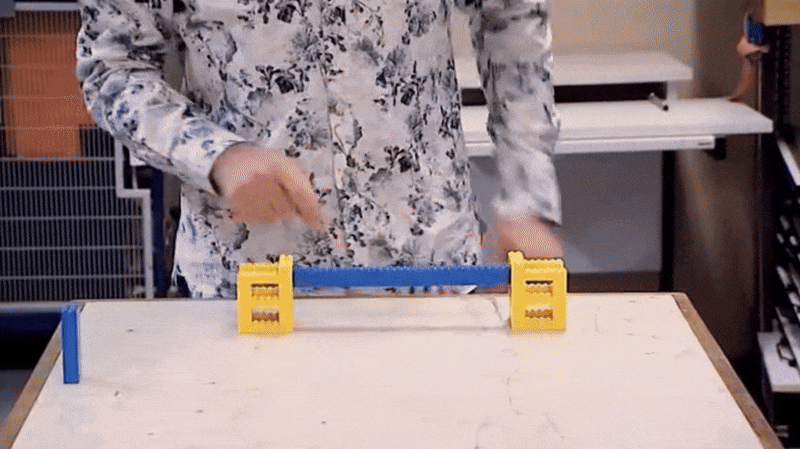 GIF of a man pushing down on a Lego beam and it breaking immediately