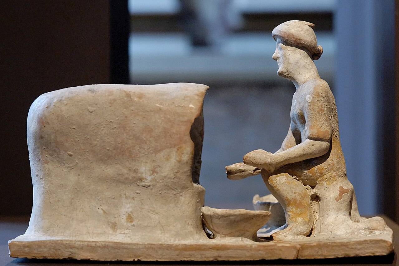 Terracotta figure of a woman taking bread out of an oven, dated ~500 B.C.E.  
