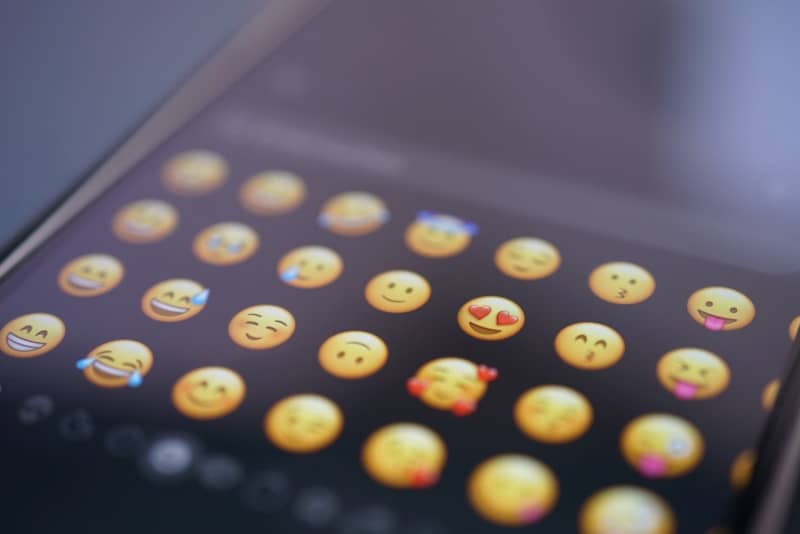 An emoji keyboard is displayed on a phone.