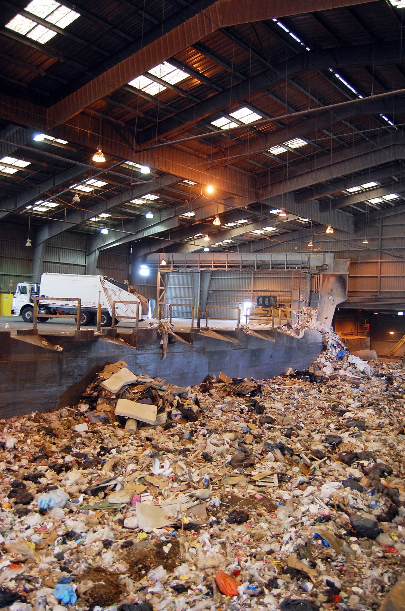 garbage truck dumping garbage into a pit at a transfer station