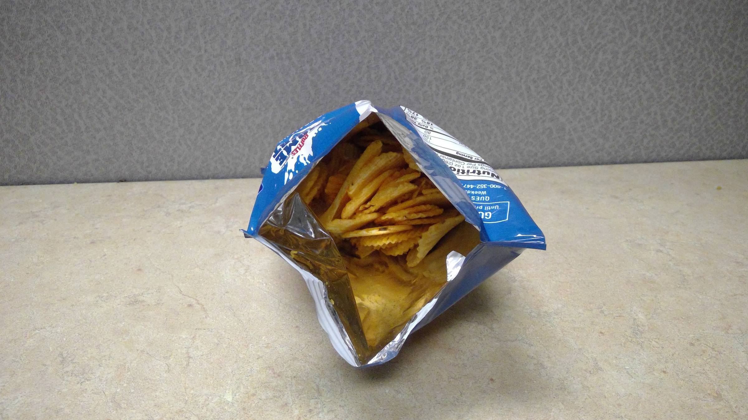 Opened bag of ruffle potato chips. 