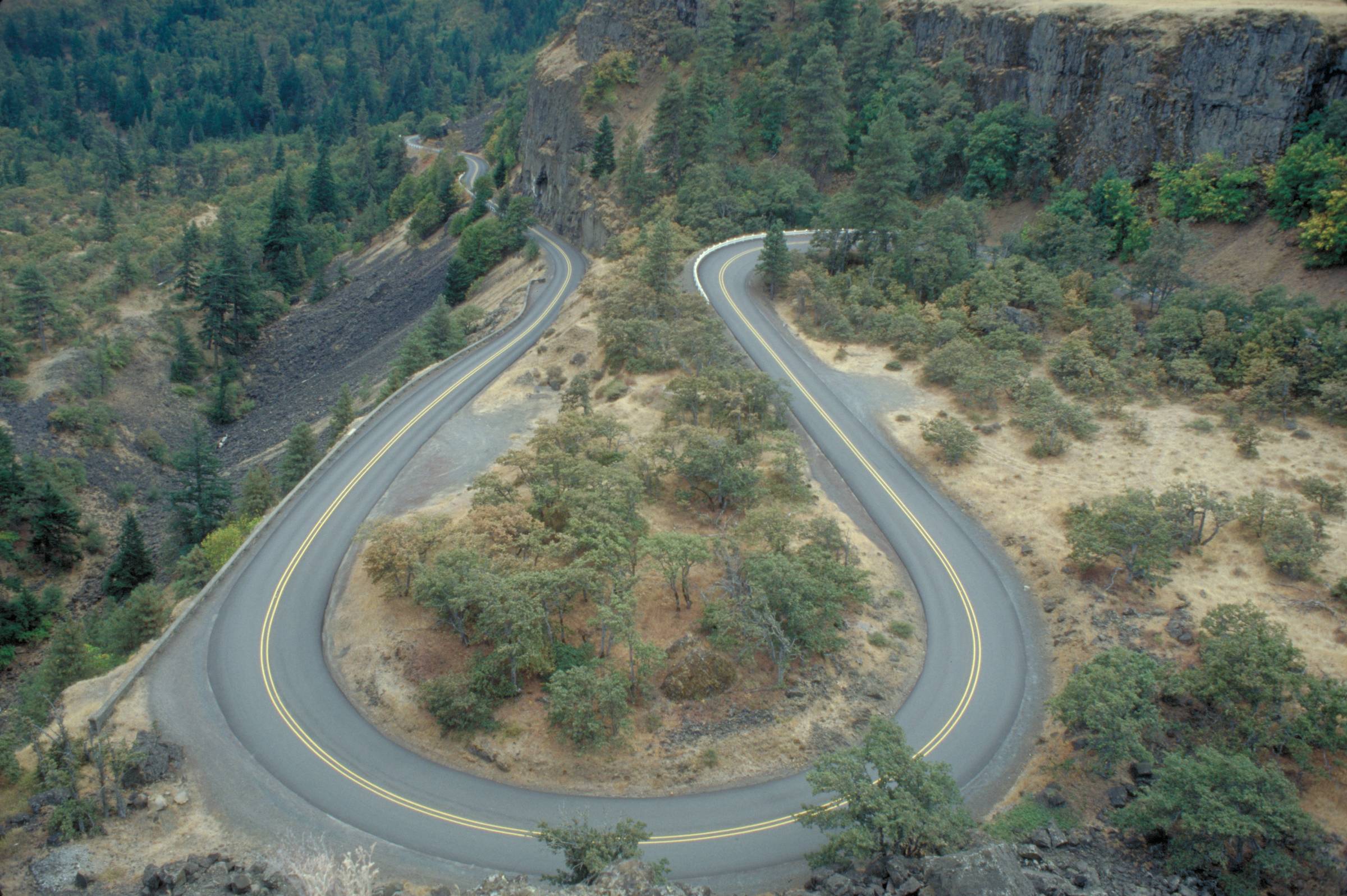 An aerial view of a road with a very tight curve 