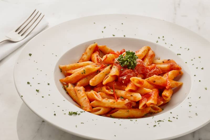 a white plate topped with pasta covered in sauce