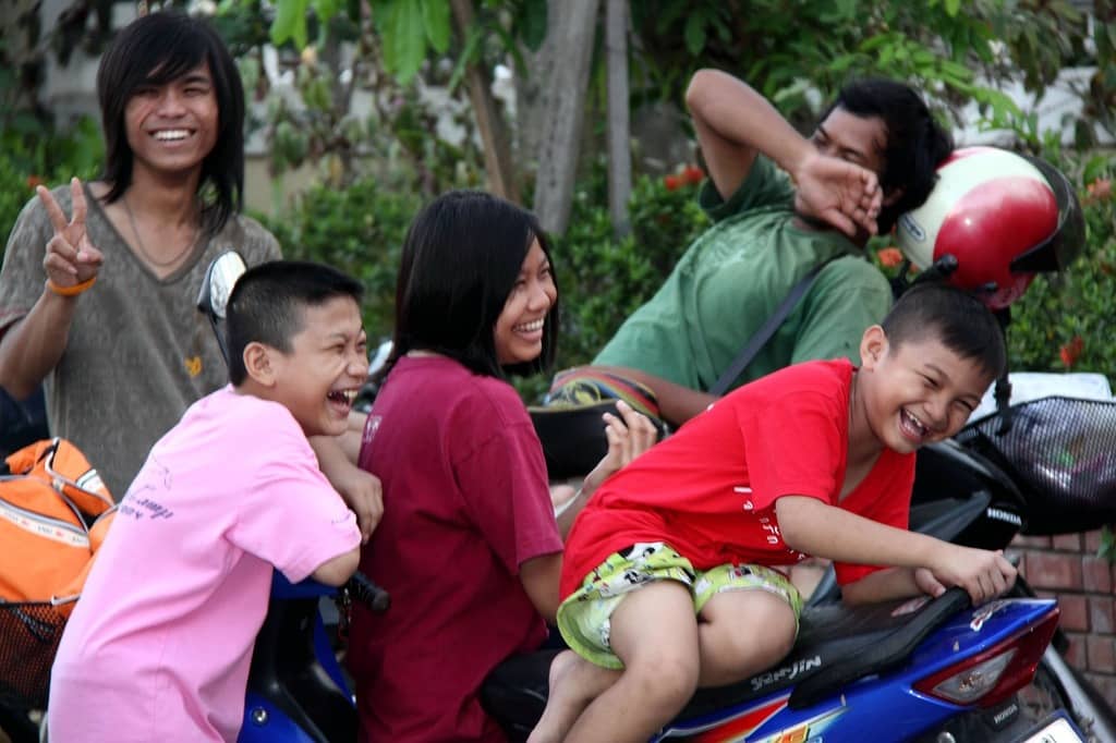 Group of people laughing while sitting on motorcycles 