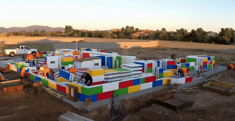 GIF of workers assembled ICF blocks colored to look like Legos