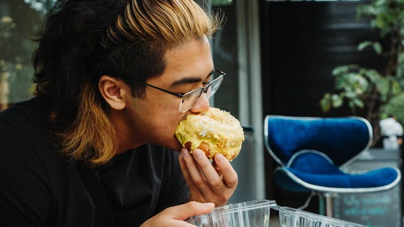 person smelling/biting a donut